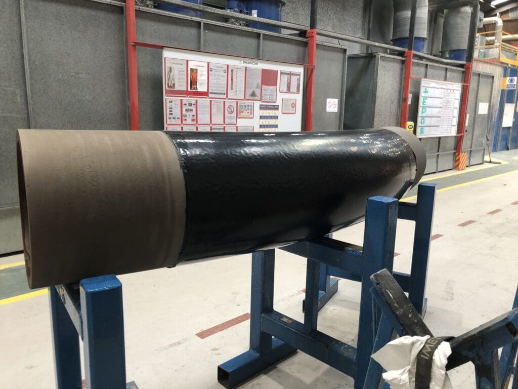 Steel pipe coated with black 2 Layer Polyethylene (2LPE) anti-corrosion system, staged at LJF Custom Coatings workshop